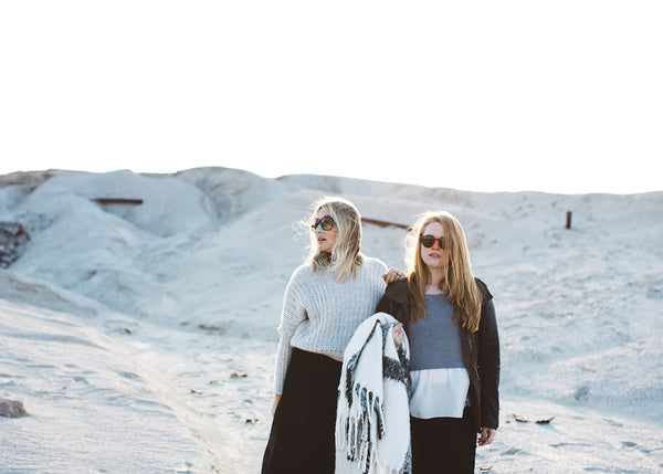 Two friends enjoying the views of the desert with a blanket