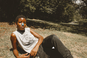 Women laying in the grass with sunscreen on her nose